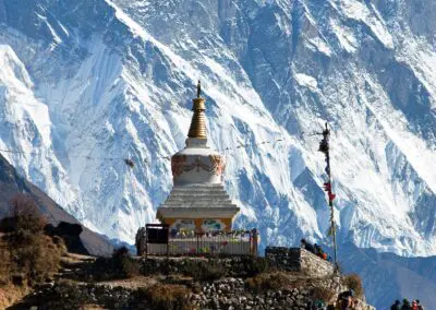 A solemn death stupa stands in serene contrast to the backdrop of a majestic snow-covered mountain, symbolizing impermanence and the cycle of life against the grandeur of nature's timeless beauty.