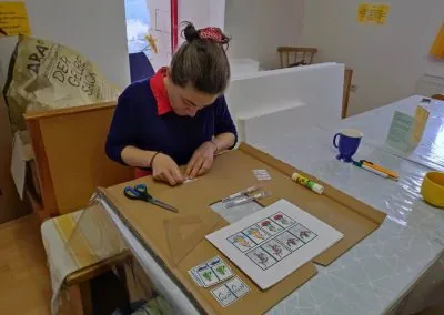 Preparing for the empowerment and initiation ceremonies, a woman carefully laminated images of different deities