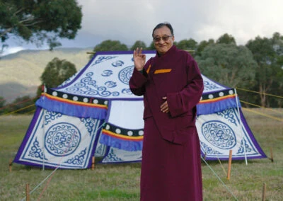 Khentrul Rinpoche standing in front of a vibrant Tibetan tent